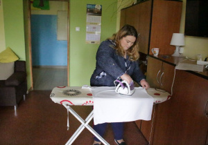 Uczennica prasuje podkoszulkę.