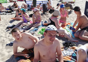 Uczestnicy Turnusu rehabilitacyjnego opalaję się na plaży.