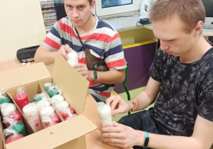 Uczniowie przygotowujący świece "Caritas" do sprzedaży
