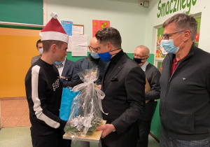 Przedstawiciele Rotary dają prezenty uczniom..