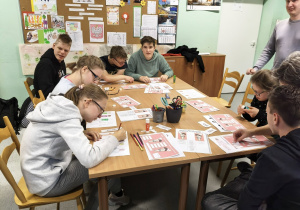 uCZNIOWIE PRZY STOLIKU WYKONUJĄ ZADANIA TESTOWE