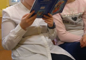 Uczennica czyta książkę.