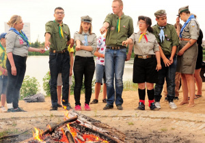 Uczestnicy obozu harcerskiego przy ognisku.