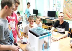 Grupa uczniów ogląda drukarke 3D