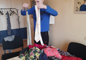 chłopiec wybiera ubrania do składania