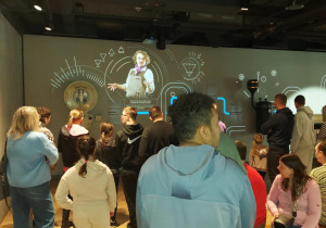 Uczniowie słuchaja wykładu o produkcji czekolady i oglądają prezentacje