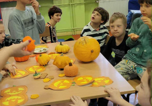 Uczniowie przy stole z kolorowymi warzywami