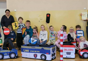 Uczniowie i strażniczki pozują na tle makiety ulic.