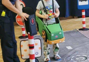 Chłopiec w samochodzie porusza się po makiecie ulicy.