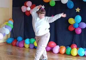 Dziewczynka tańczy na tle dekoracji do konkursu Mam talent