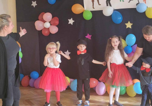 Przedszkolaki z nauczycielem prezentują swój układ taneczny.