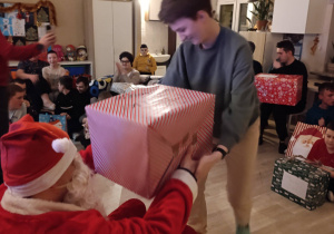 Uczennica odbiera prezent od Mikołaja.