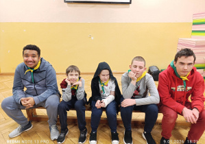 Na zdjęciu siedzą harcerze.