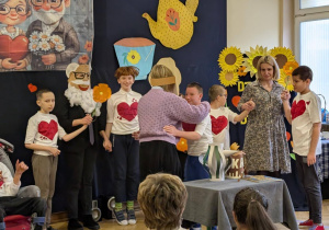 Zdjęcie przedstawia uczniów podczas przedstawienia dla babć i dziadków.