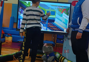 Uczeń rozwiązuje zadania na tablicy interaktywnej.