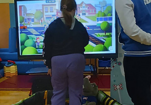 Uczennica rozwiązuje zadania na tablicy interaktywnej.