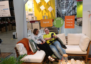 Dziewczyna i chłopak siedzą w sklepie IKEA na meblach wypoczynkowych do ogrodu