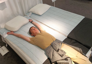 Chłopiec leży z uniesionymi rękami na materacu w IKEA