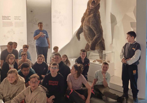 Uczniowie ogladają eksponaty w muzeum w Zakopanem. Na zdjęciu eksponat niedźwiedź