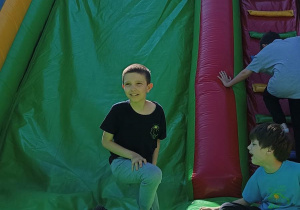 Uczniowie bawią się na dużej dmuchanej zjeżdżalni