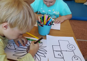 Dziewczynka i chłopiec kolorują obrazki.